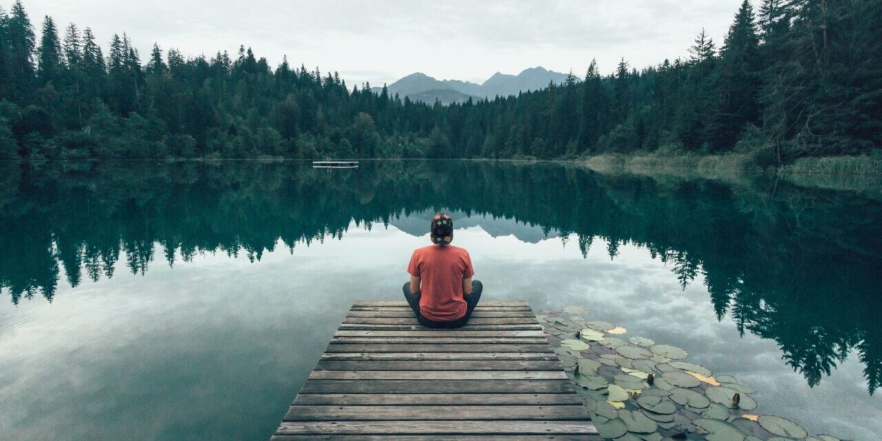 person sitting on dock meditating for anxiety relief