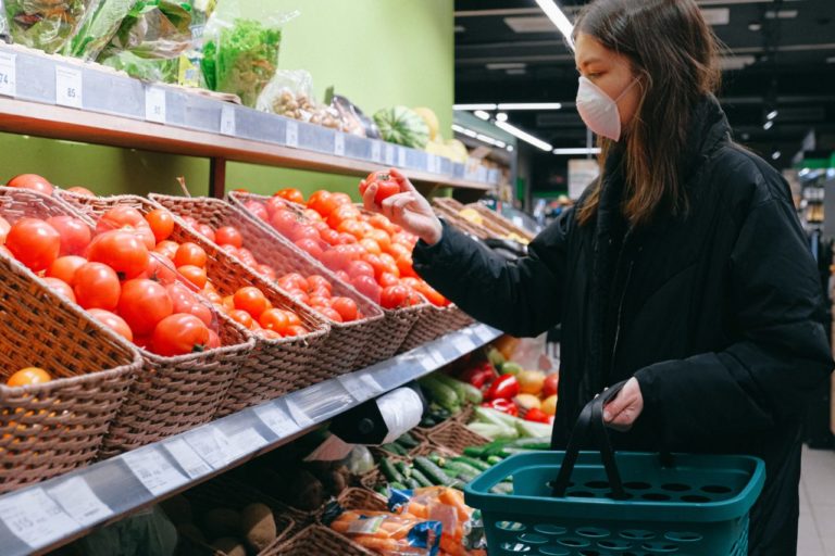 woman wearing mask and buying food in supermarket during coronavirus pandemic