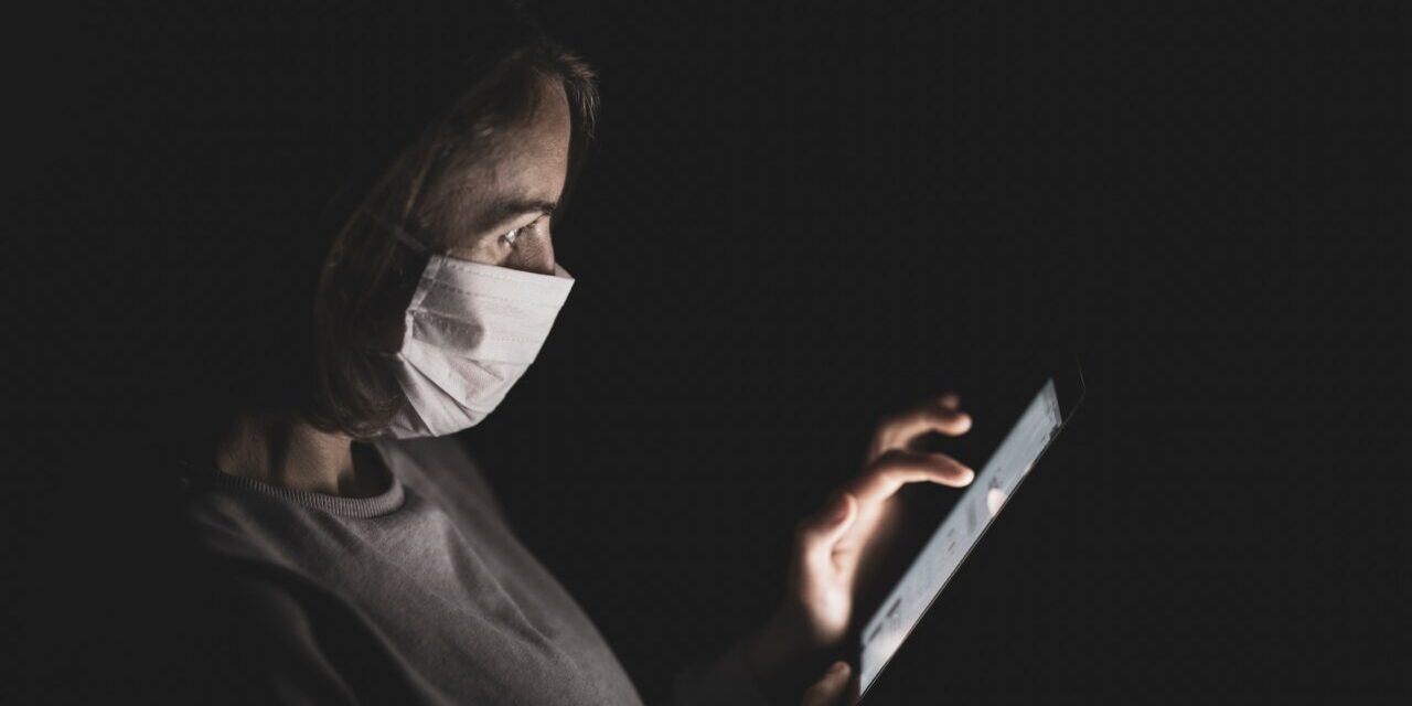 woman wearing mask on phone
