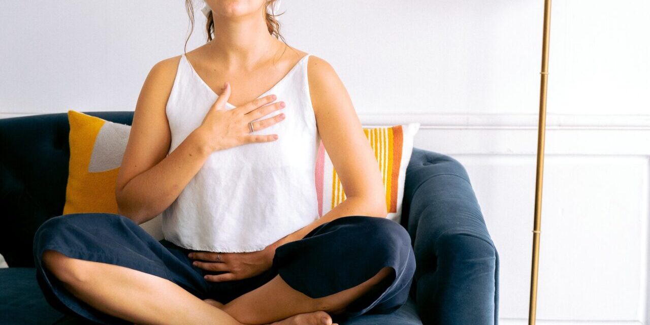 woman practicing breathing on couch