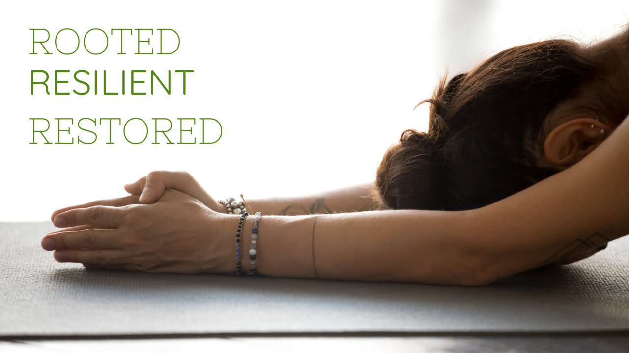 Person in a grounded yoga pose with hands clasped on a mat, symbolizing rest, resilience, and restoration.