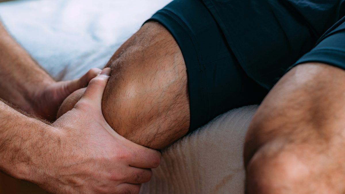 Physical therapist performing hands-on knee treatment