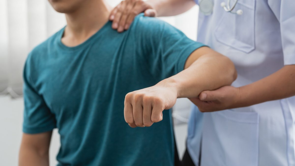 Physical therapist assessing a patient's shoulder mobility